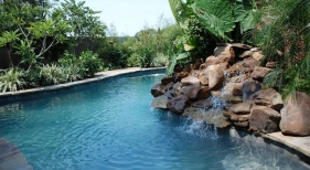 natural-shape-pool-with-flagstone-coping-rock-waterfall-diamond-brite-french-gray-plaster-finish