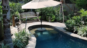 freeform-gunite-pool-with-cocktail-table-flagstone-bench-flagstone-coping-umbrella-holder