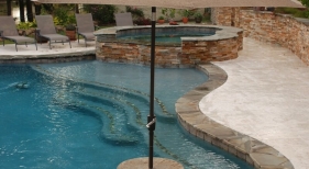 freeform-gunite-pool-with-negative-edge-granite-cocktail-table-bench-tanning-ledge-raised-spa-flagstone-ledger-stone
