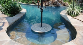 natural-gunite-lagoon-pool-with-rock-waterfall-and-pool-granite-cocktail-table-with-umbrella-holder